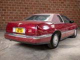 a red car that is parked in front of a brick wall
