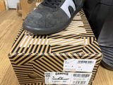 a pair of black and white sneakers sitting on top of a box
