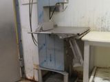 une image d'une cuisine avec un réfrigérateur et une table
