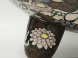 a large bowl with flowers on it sitting on a stand