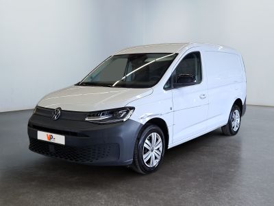 La camionnette blanche est garée dans une grande pièce au sol noir