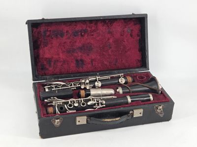 a black case with a silver and black clarinet in it