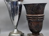 two silver vases sitting next to each other on a table