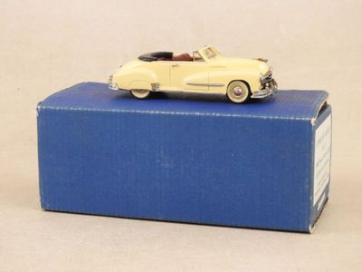 une petite voiture jaune posée sur une boîte bleue