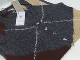 a sweater with a tag on it sitting on a table