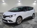une voiture blanche garée sur un sol en damier dans un garage