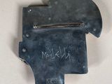 a metal object with writing on it on a white surface