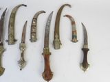 several knives are lined up on a white surface with a white background