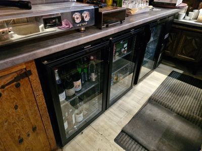 un bar avec une porte vitrée et un comptoir sur lequel sont disposées des bouteilles de vin