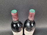 two bottles of wine sitting next to each other on a table
