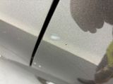 a close up of a car ' s door with a person standing next to it