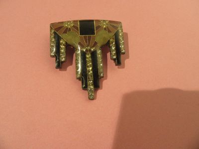 a gold brooch with black and white stones on it