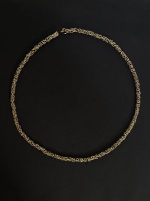 a gold necklace on a black background