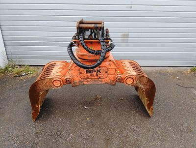 une grosse machine orange garée devant une porte de garage