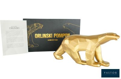 figurine d'un ours doré devant une boîte noire recouverte d'une feuille d'or