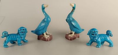 three blue figurines of birds and a dog on a table