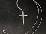 a silver cross on a chain on a black background