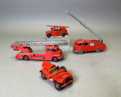 quatre camions de pompiers miniatures et un camion de pompiers posés sur une table