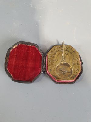 une petite boîte rouge contenant une médaille en or