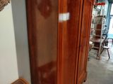 a tall wooden cabinet in the corner of a room