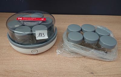 un bocal rempli de bocaux et un récipient contenant des bocaux posés sur une table