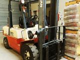 a fork lift truck parked in a warehouse with pallets on the floor