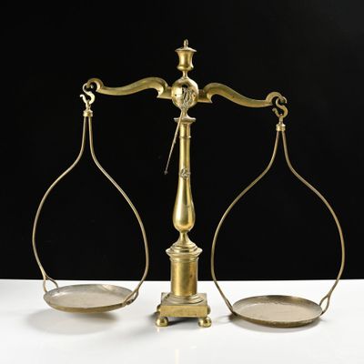 une vieille balance en laiton sur laquelle se trouvent deux plateaux