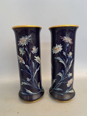 deux vases avec des fleurs peintes dessus, posés sur une table