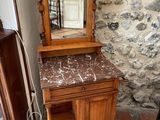a wooden vanity with a marble top and a mirror
