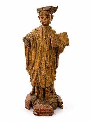 une vieille statue représentant un homme tenant un livre et portant un chapeau