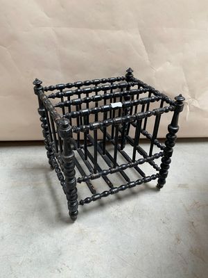 une petite cage en métal sur laquelle sont enfilées plusieurs perles noires