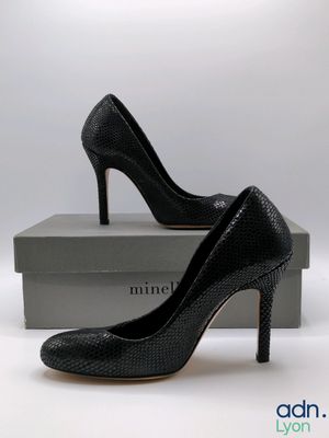 a close up of a pair of black high heels on a box