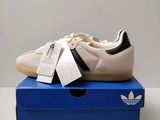 une paire de chaussures Adidas posée sur une boîte bleue