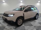 La Dacia blanche est garée dans une grande pièce au sol carrelé en damier.