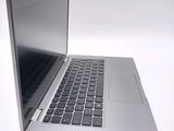a silver laptop with a black keyboard on a white surface