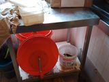 une table en métal sur laquelle sont posés deux seaux, dans une cuisine