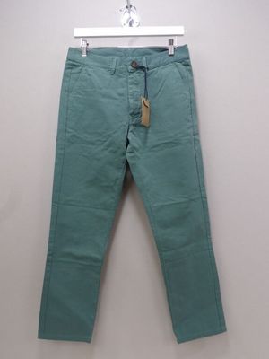 un pantalon vert suspendu à un cintre accroché au mur