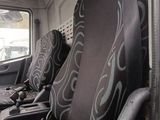 two seats in the back of a bus that are covered with seat covers