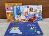 three children ' s books sitting on a bed with a wooden headboard
