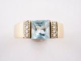une image d'une bague avec une topaze bleue entourée de diamants