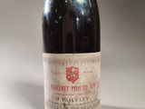 an old bottle of wine sitting on top of a white table