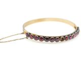 un gros plan d'un bracelet en or orné de grenats