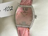 a pink watch with diamonds on it sitting on a display case
