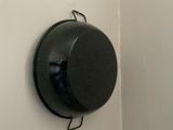 a black object hanging on the wall next to a toilet