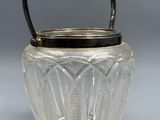a glass jar with a handle on a table