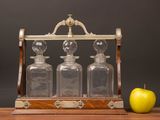 an apple sitting next to a set of three glass decanters