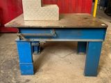 une table bleue sur laquelle est posé un bloc, devant un mur rouge