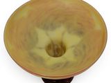 a yellow bowl with a hole in it on a white surface