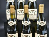 six bouteilles de vin sont alignées sur un fond noir