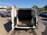 the back of a white van with its door open in a parking lot